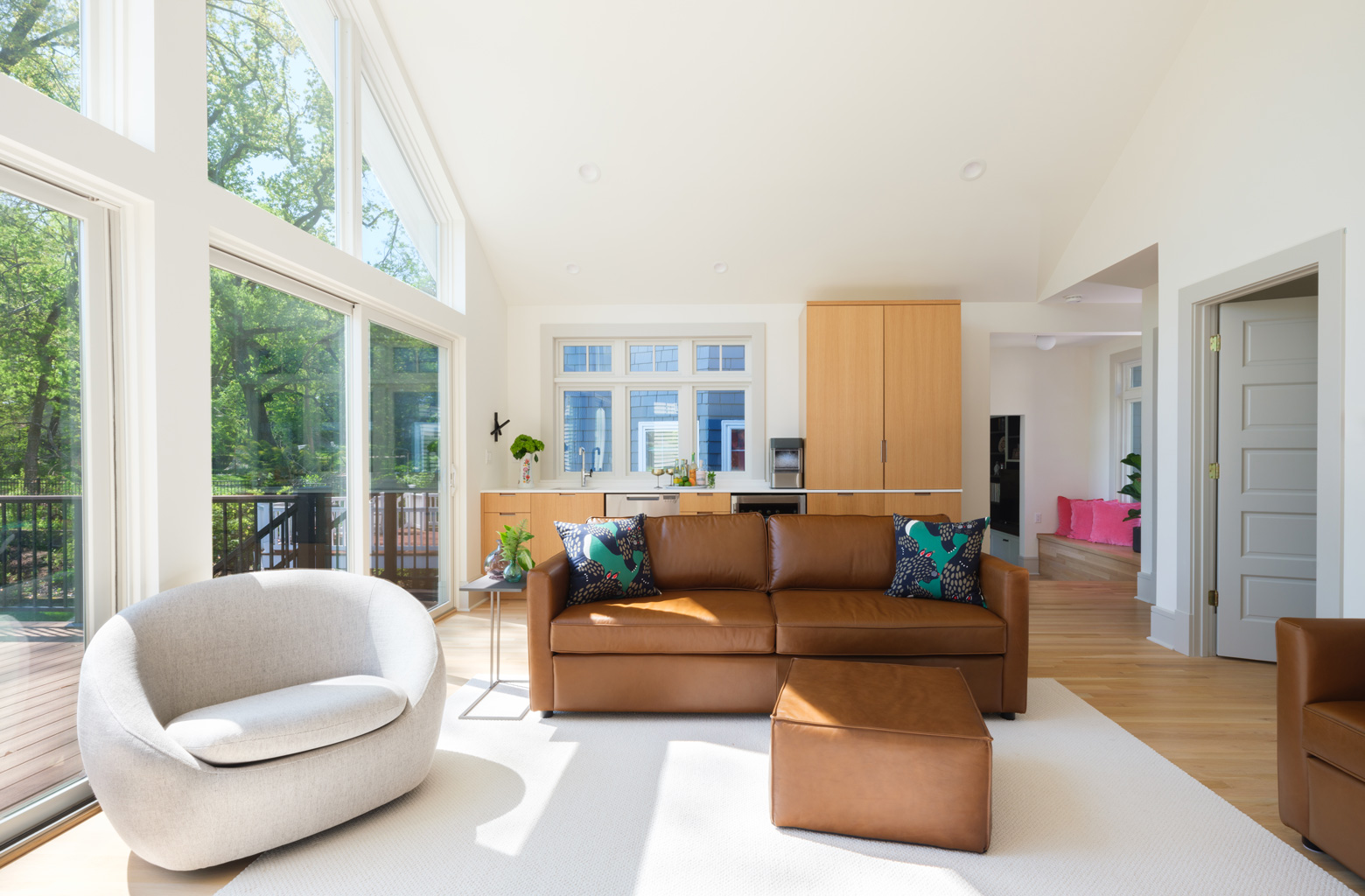 Living room with floor-to-ceiling windows and leather seating in Webster Groves, Missouri — multi-room remodel by Hercules Design Build